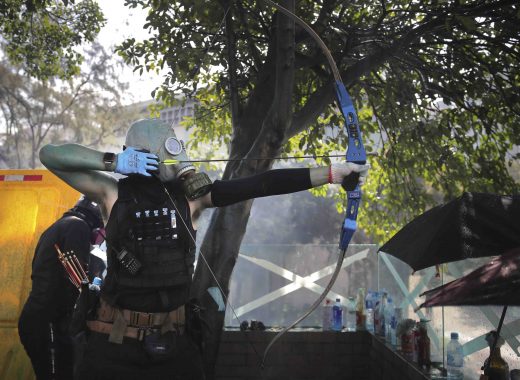 Un manifestante de Hong Kong dispara una flecha contra las fuerzas de seguridad