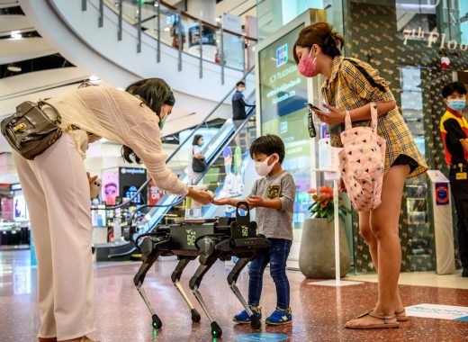Un perro robot reparte gel para las manos en un centro comercial