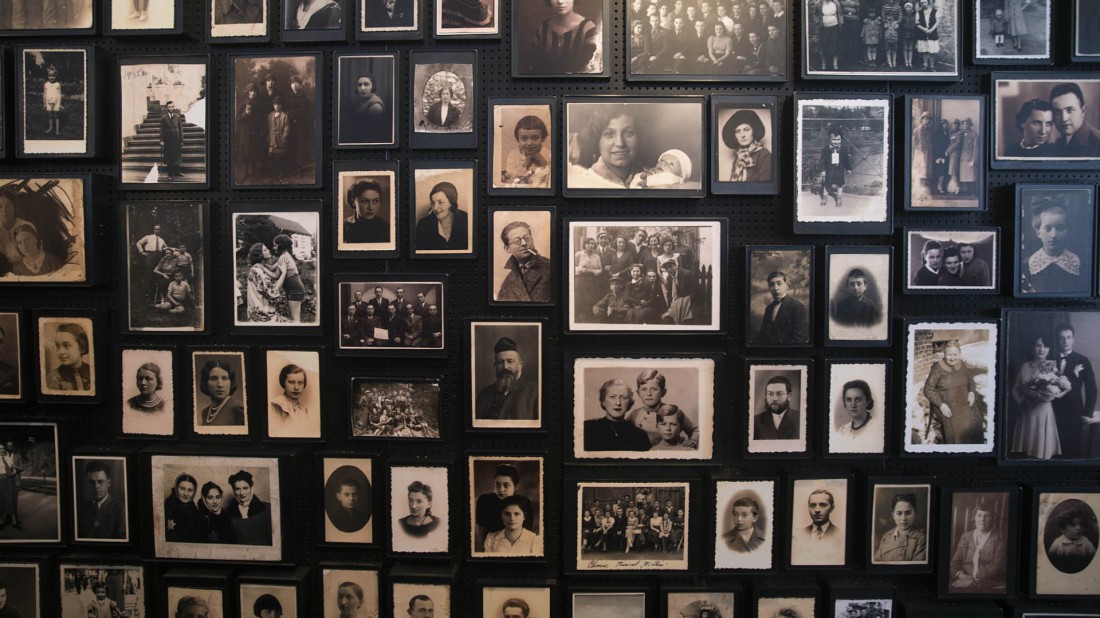 Una pared repleta de fotografías históricas decora el memorial del campo de concentración.