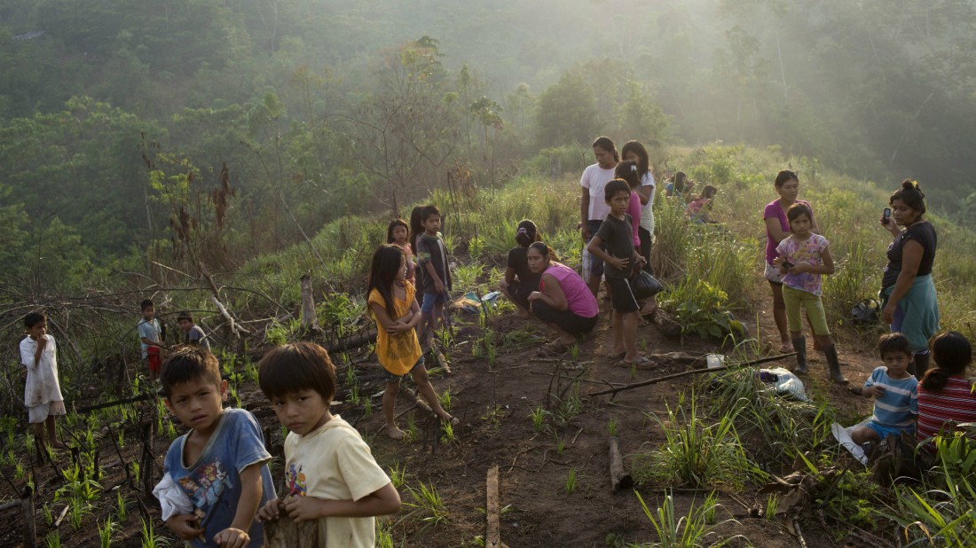 Personas esperan mientras los trabajadores erradican las plantaciones de coca en las granjas de sus familias con la esperanza de que les den alimento. Foto por Rodrigo Abd.
