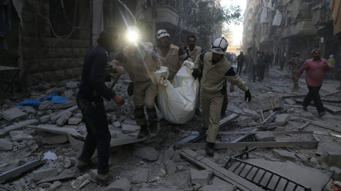 Personal de emergencias carga un cuerpo luego de un ataque aéreo en Siria. AFP PHOTO / BARAA AL-HALABI