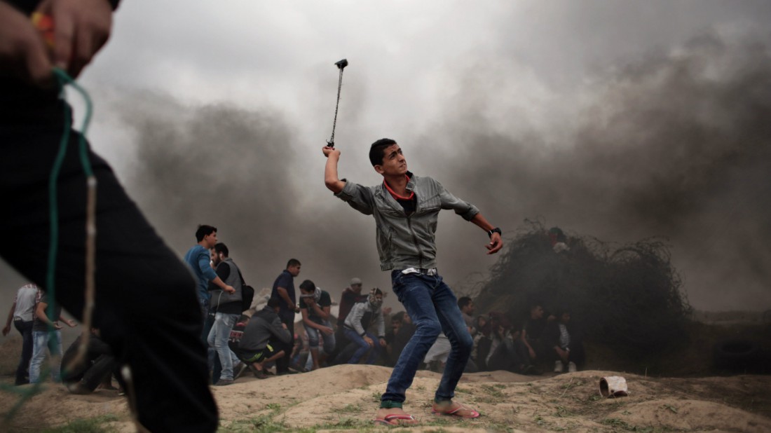 Un manifestante palestino lanza piedras durante enfrentamientos con soldados israelíes en la fronetra de Gaza. AP Photo/ Khalil Hamra
