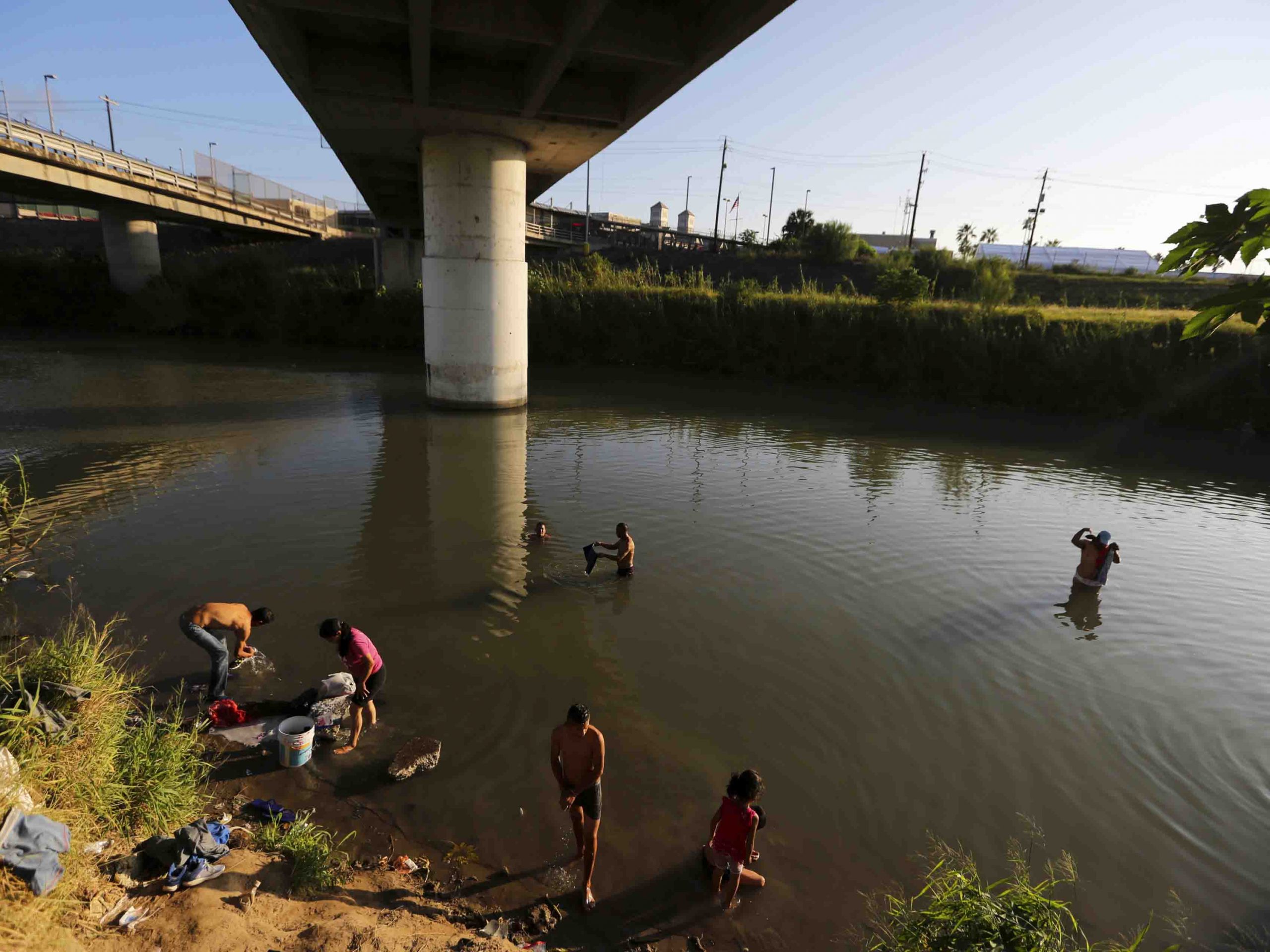 Migrantes lavan sus ropas cerca de la frontera con Estados Unidos