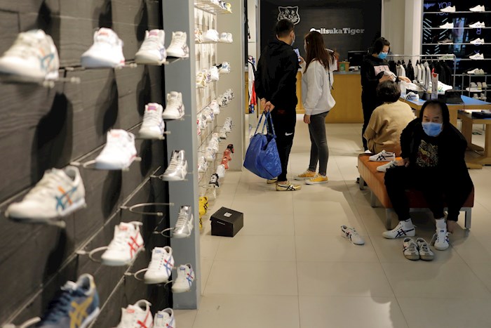 Personas con máscaras faciales compran en una zapatería de un centro comercial en Pekín, hoy 20 de marzo de 2020. Muchos restaurantes, tiendas y otras empresas comienzan a recuperarse y cerraron durante el brote de coronavirus COVID-19 en China. Países de todo el mundo están tomando mayores medidas para detener la propagación del coronavirus SARS-CoV-2 que causa la enfermedad de Covid-19. EFE/WU HONG