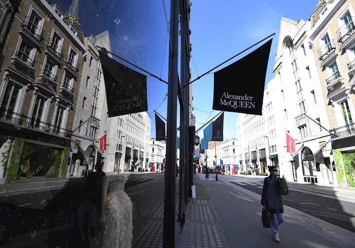 Una mujer pasa por delante de la tienda de Alexander McQueen en la calle Old Bond de Londres (Gran Bretaña), el 24 de marzo de 2020.