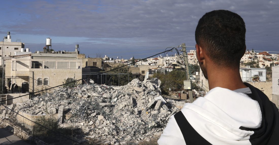 A Palestinian man looks at the remains of a house, after it was demolished by Israeli bulldozers, in the village of Idna, near the West bank town of Hebron on November 27, 2024. (Photo by HAZEM BADER / AFP)