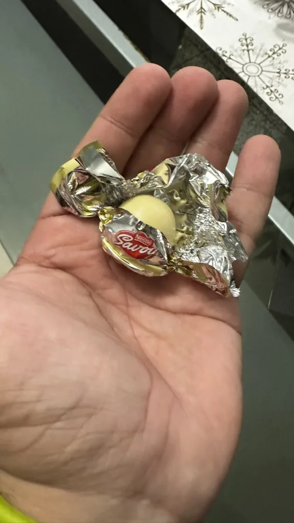 El Toronto Nevado es el tradicional bombón perfectamente esférico y brillante, hecho de chocolate de leche con minitrocitos de frutos secos y al centro una avellana entera, pero con una capa de chocolate blanco que lo envuelve todo