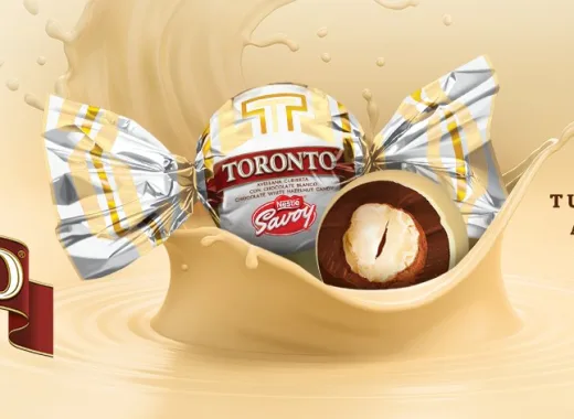 El Toronto Nevado es el tradicional bombón perfectamente esférico y brillante, hecho de chocolate de leche con minitrocitos de frutos secos y al centro una avellana entera, pero con una capa de chocolate blanco que lo envuelve todo.