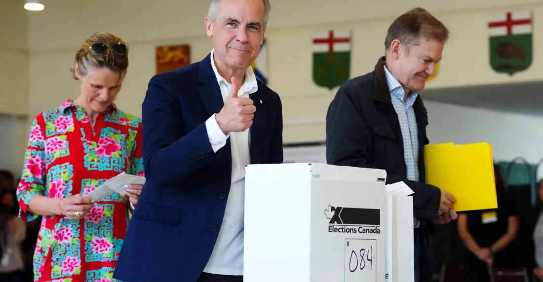 Canadian Prime Minister and Liberal leader Mark Carney, alongside his wife Diana Fox Carney (L), gives a thumbs up after casting his ballot a polling station during the federal election in Ottawa, Canada on April 28, 2025