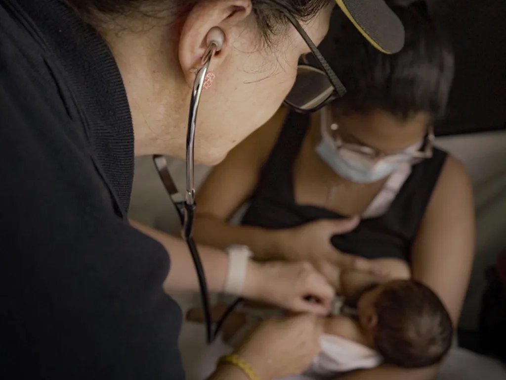El hospital de campaña de Reino Unido finaliza su misión: estos fueron sus aportes Una pediatra ausculta el pecho de un bebé con un estetoscopio durante una consulta en el hospital de campaña.